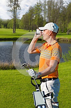 Man golfer watching into rangefinder photo