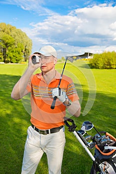 Man golfer watching into rangefinder photo
