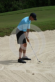 Man Golfing From Sand Bunker