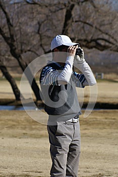 Man Golfing Using Rangefinder photo