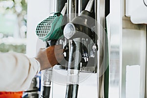 Man grabbing a fuel nozzle to refuel his vehicle