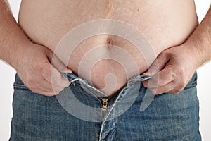 Man grabbing his fat on the stomach