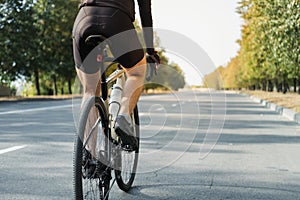 Man on a gravel bike on the road, back view.