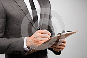 Business Professional Writing Notes on Clipboard in a Formal Setting During Office Hours