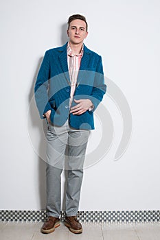 The man in gray trousers and a cyan jacket