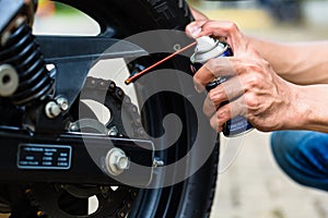 Man greasing motorcycle chain