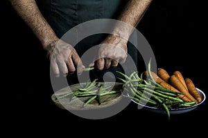 Man with green apron presenting vegetables and garden vegetables