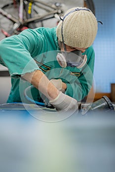 Man in green overalls preparing an engine bay