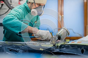 Man in green overalls preparing an engine bay