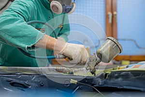 Man in green overalls preparing an engine bay