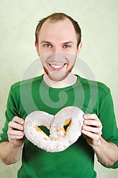 Man in green shirt holding big cracknel photo
