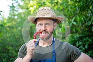 man greengrocer in straw hat with chili pepper vegetable