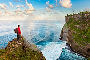 Man greeting nature on the top of mountain