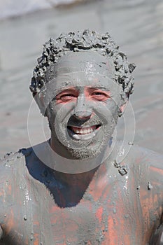 Man in grey mud bath. Dalyan, Turkey