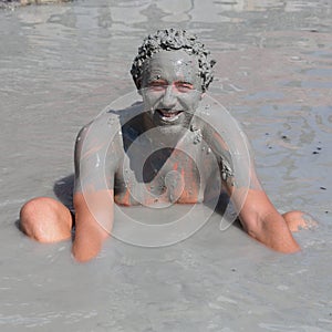 Man in grey mud bath. Dalyan, Turkey