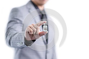 Man in grey suit showing a Covid-19 vaccine in his hand