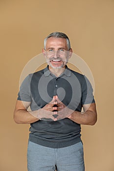 A man in a grey tshirt looking confident and smiling photo