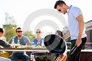 Man grilling on bbq at rooftop party