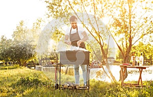 Man grilling food on lake shore