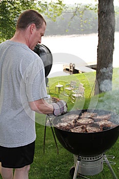 Man grilling steaks for 4th of July holiday picnic
