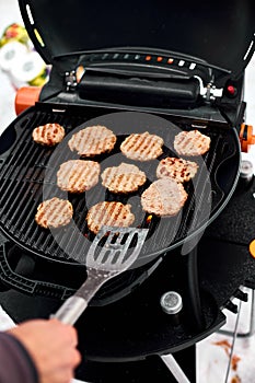 Man grilling steaks on a portable BBQ, Snowy winter barbecue