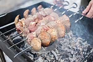 A man grills meat and mushrooms in winter. close-up. Winter picnic, outdoor recreation. defocus