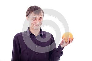 Man grimace holding sour fruit