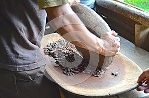 Man grinding cacao beans photo