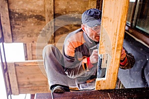 Man grinding planks of wood for home construction.
