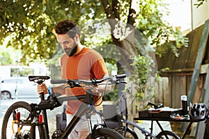 Man gripping damaged bicycle in yard