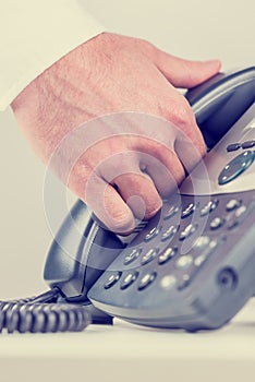 Man gripping a telephone receiver in his hand photo