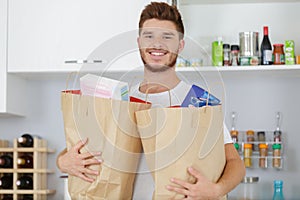 Man with grocery bag in kitchen room