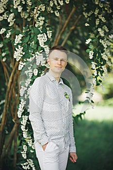 Man, groom posing in park on his wedding day