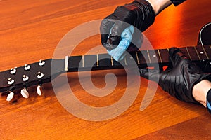 man with a guitar,hands of a master in gloves with a classical guitar fretboard.cleaning of musical instruments