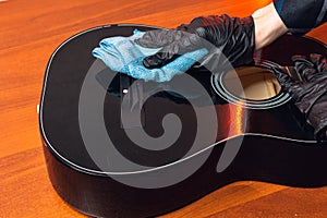 man with a guitar,hands of a master in gloves with a classical guitar front deck.cleaning of musical instruments