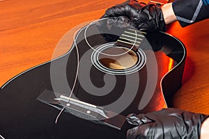 man with guitar,master hands in gloves puts on new strings .repair of musical instruments