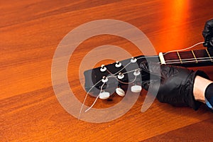 man with guitar,master hands in gloves puts on new strings .repair of musical instruments