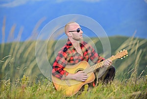 Man with guitar on top of mountain. In unison with nature. Keep calm and play guitar. Acoustic music. Music for soul