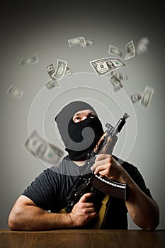 Man with gun and dollar banknotes.