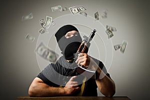 Man with gun and dollar banknotes.