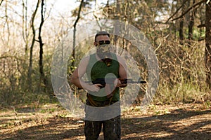 A man with a gun in a forest