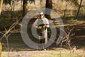 A man with a gun in a forest