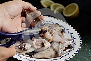 Man gutting some raw cuttlefishes