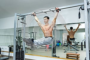 Man in gym doing some exercises on crossbar
