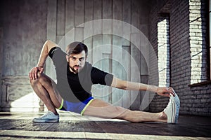 Man at the gym doing stretching exercises