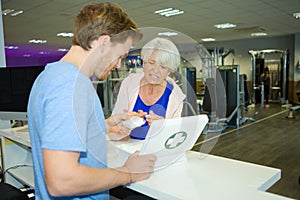 man in gym giving plaster to lady with cut finger