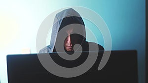 Man hacker in the hood concept. unknown hacker criminal breaks into computer protection on the Internet passwords. male