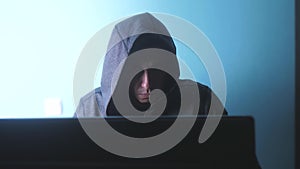 Man hacker in the hood concept. unknown hacker criminal breaks into computer protection on the Internet passwords. male