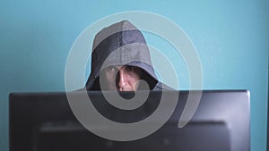 Man hacker in the hood hacking network concept. unknown hacker criminal breaks into computer protection on the Internet
