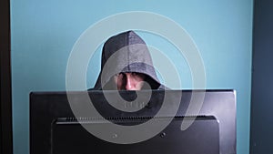 Man hacker in the hood hacking network concept. unknown hacker criminal breaks into computer protection on the Internet